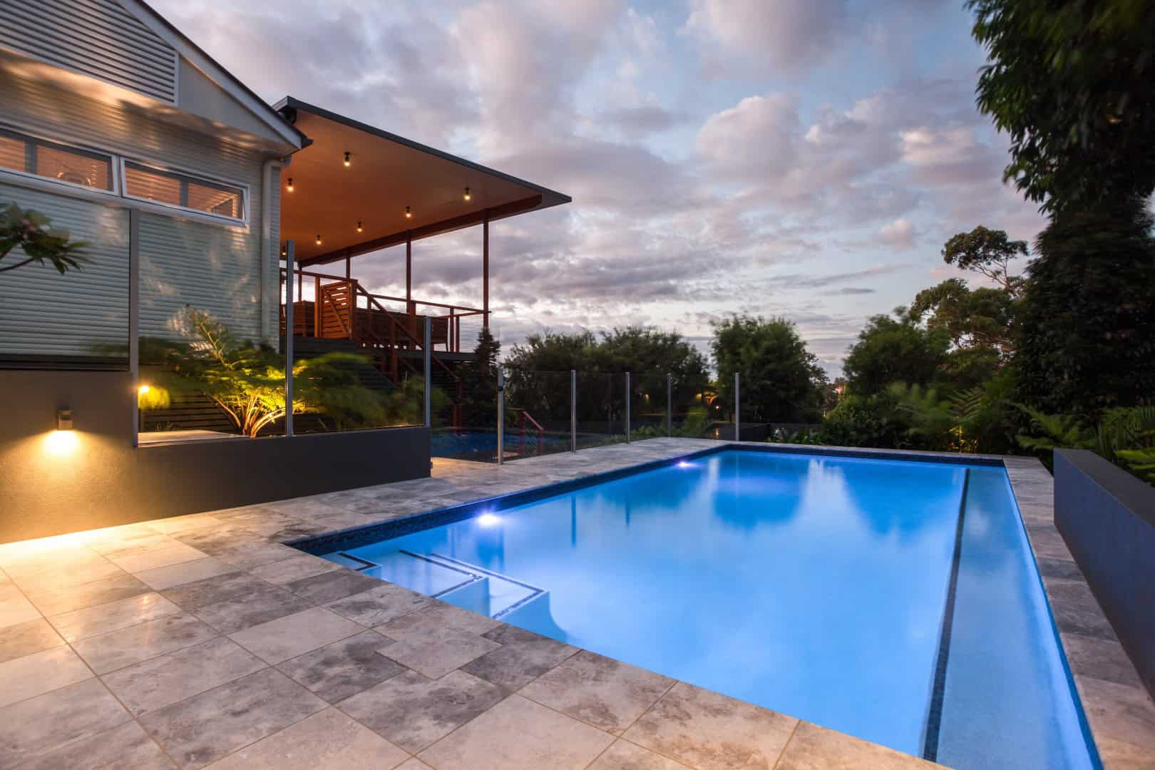 night view of a modern house with a rectangular pool